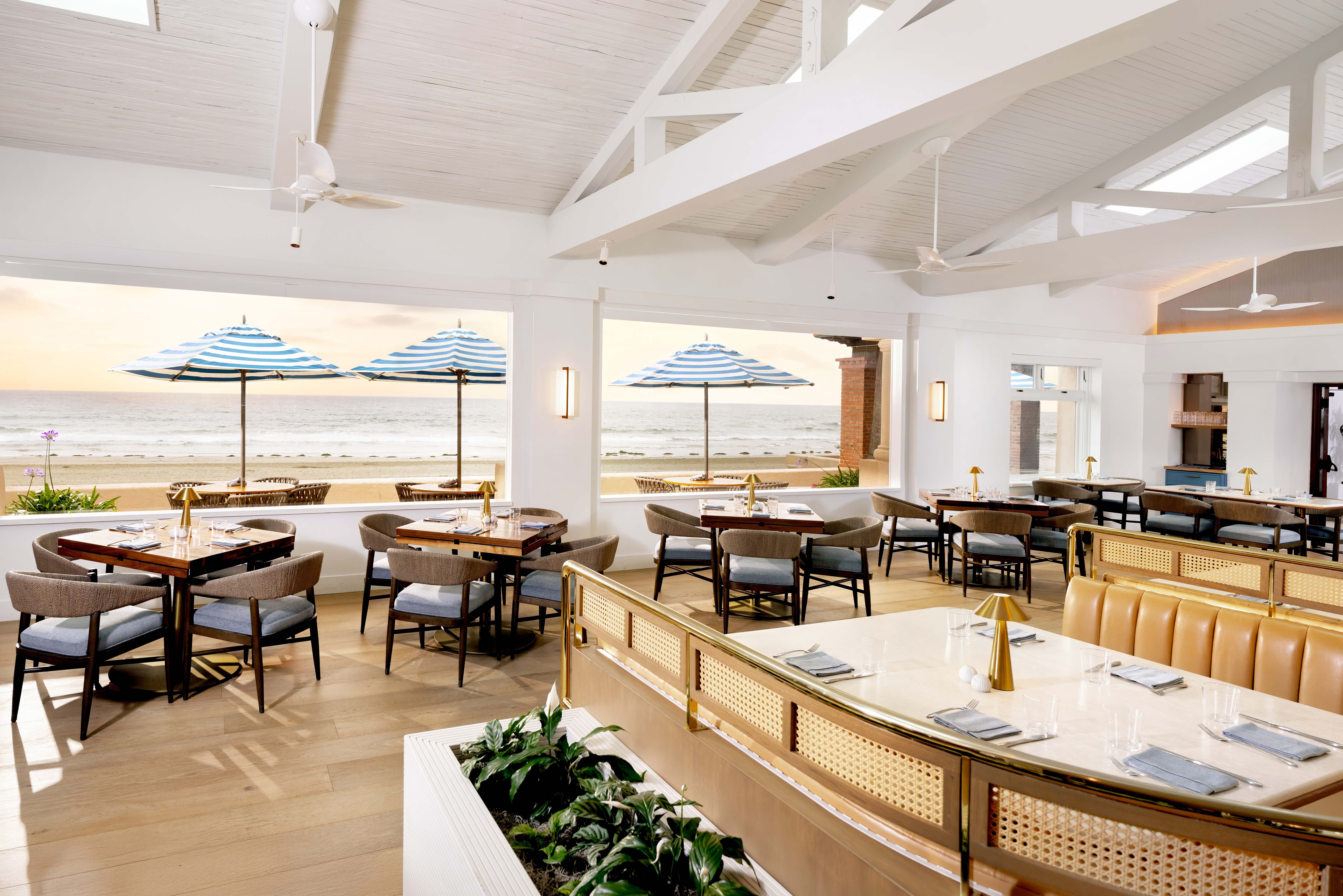 Bright oceanfront dining room at Club Dining with tables looking out to the beach